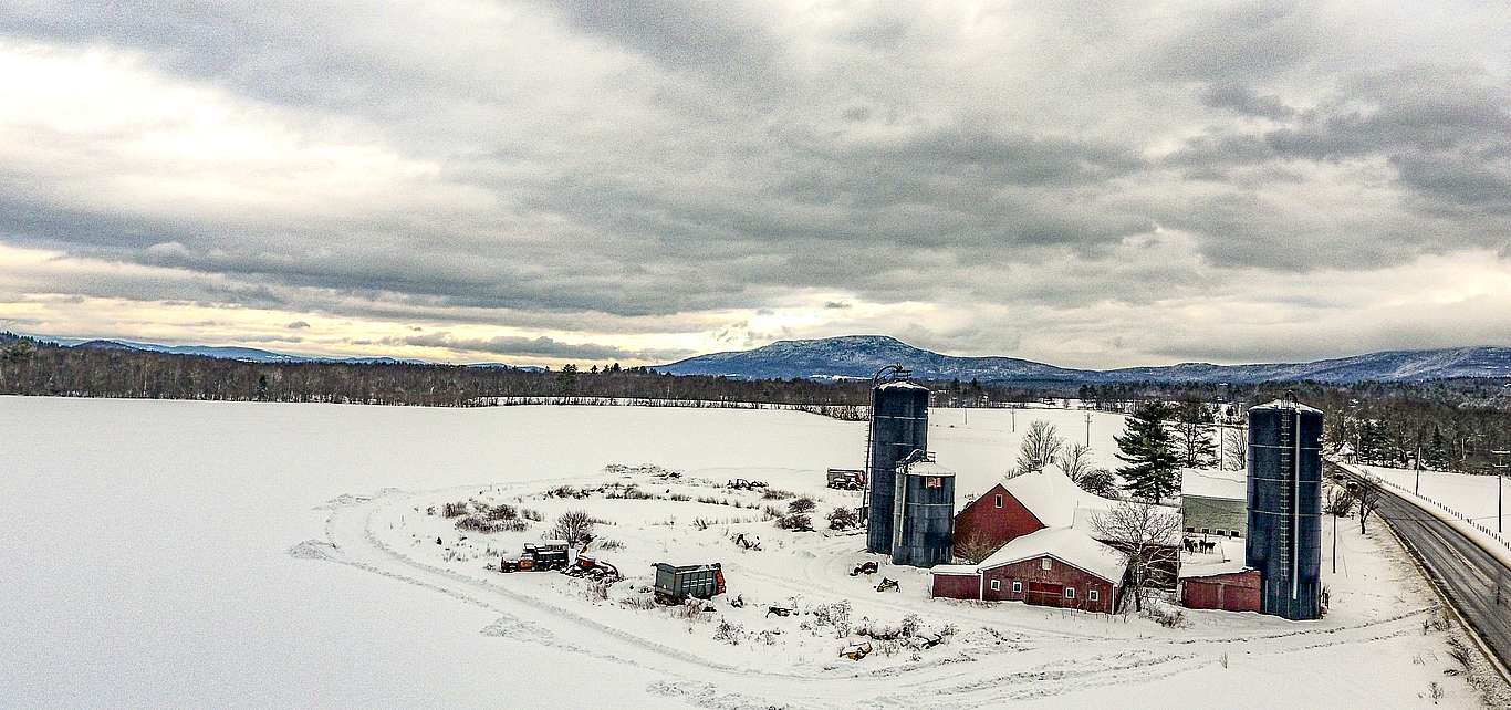Photo by Rich Levine A snow-covered barn with three silos