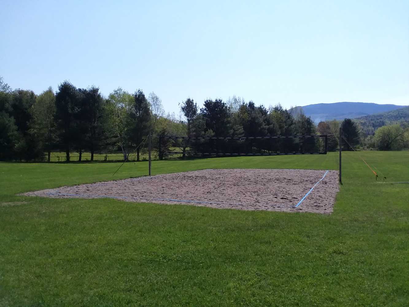 A volleyball court and recreational fields
